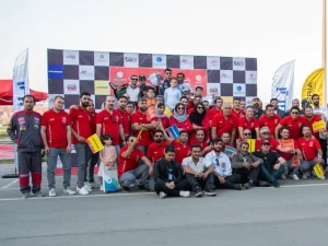 تصویر دسته جمعی از شرکت کنندگان مسابقات کارتینگ rotax max سال 1403 و همکاران پی تی سی گروپ در جلوی سکوی رتبه بندی